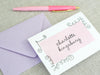 a pink pen sitting on top of an envelope