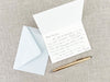 a note, pen, and envelope on a table