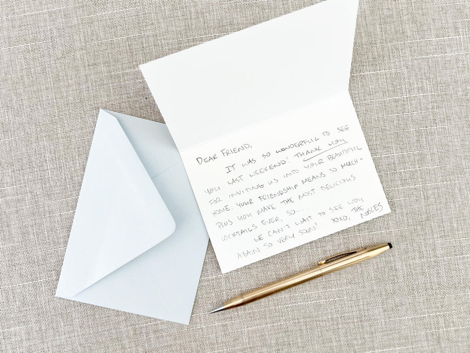 a note, pen, and envelope on a table