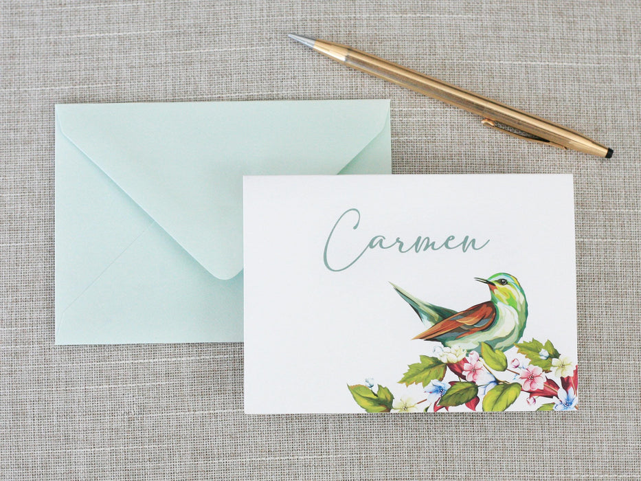 a card with a bird on it next to a pen and envelope