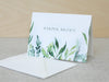 a card with a watercolor painting of leaves on it
