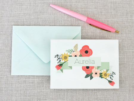 a pink pen next to an envelope with a name on it