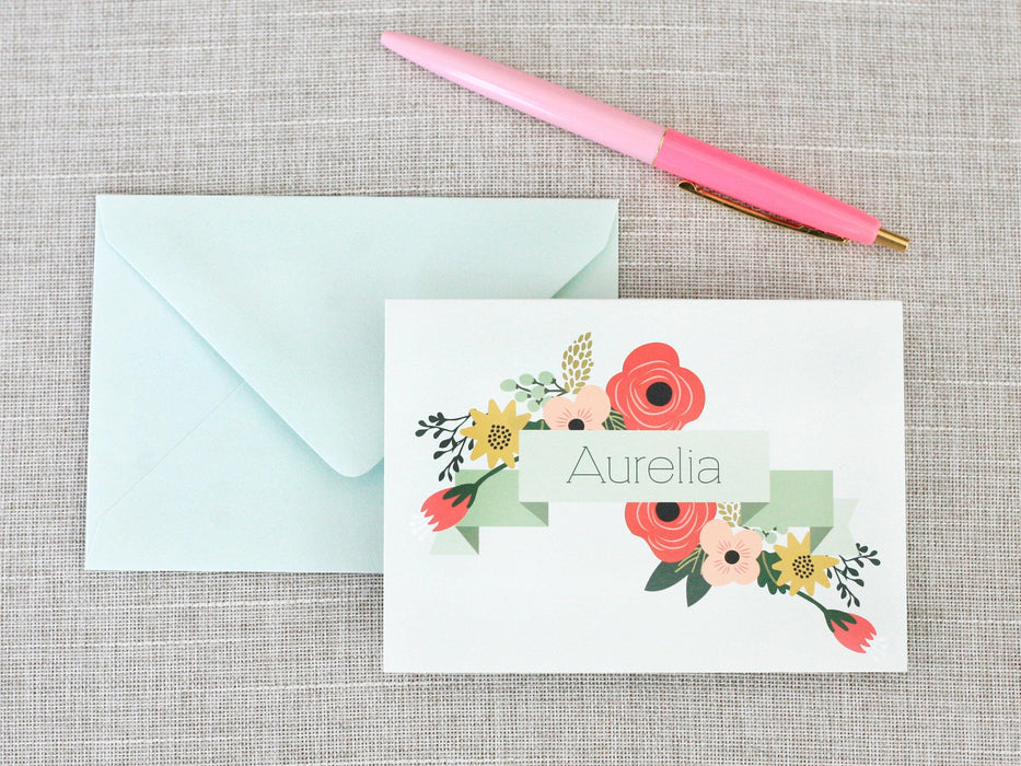 a pink pen next to an envelope with a name on it