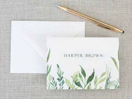 a note card with a watercolor painting of leaves
