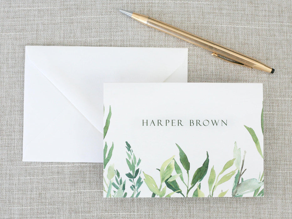 a note card with a watercolor painting of leaves