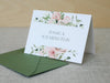 a white card with pink flowers on it