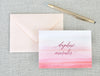 a pink and red watercolored greeting card with a pen